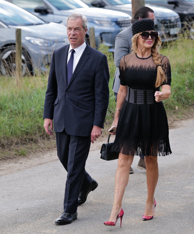 Nigel Farage and a woman in black attending James Whale's funeral.