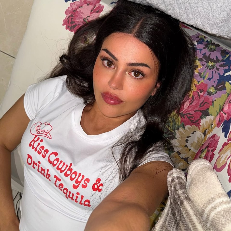 Woman wearing a "Kiss Cowboys & Drink Tequila" shirt.