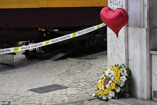A flower wreath and a balloon are placed next to the site of the crash, on September 4, 2025