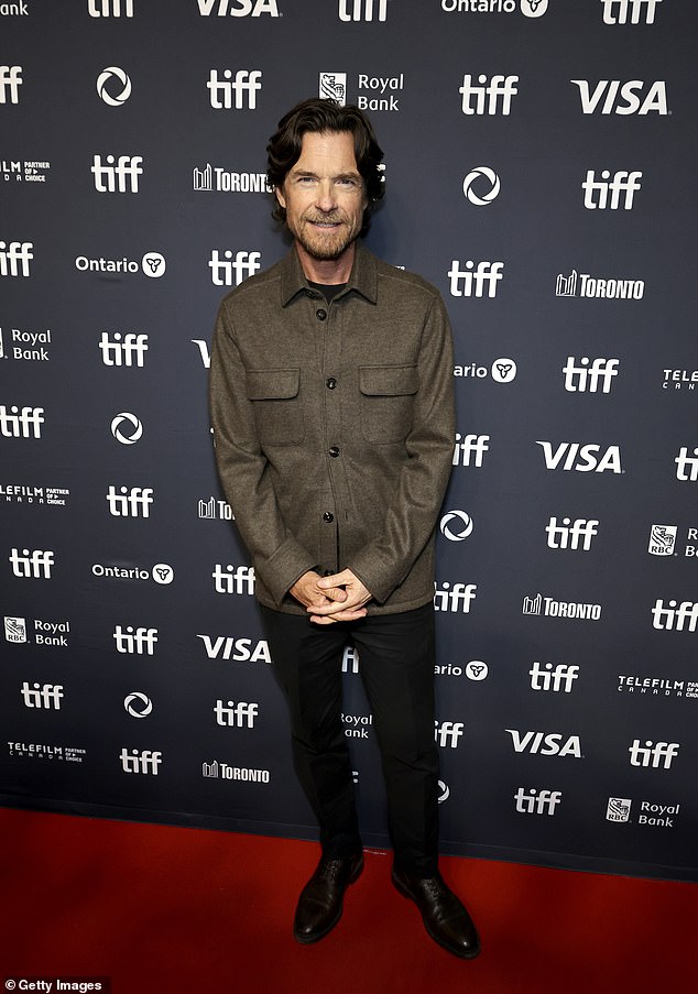 Jason wore an olive green button-down top over a black T-shirt with dark slacks as his wife had on a black vest with Capri slacks