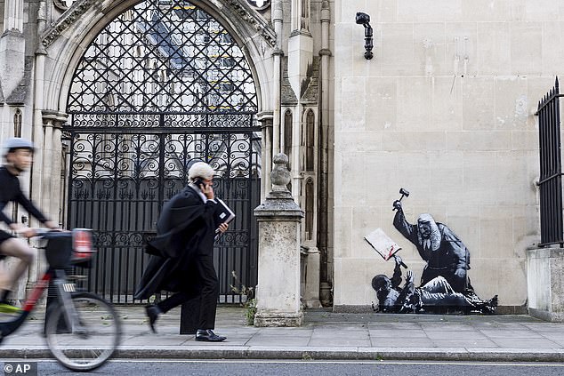 The artwork, which depicts a judge beating a protester with a gravel, was graffitied on the Grade I-listed building on Monday, before being swiftly covered up by officials.