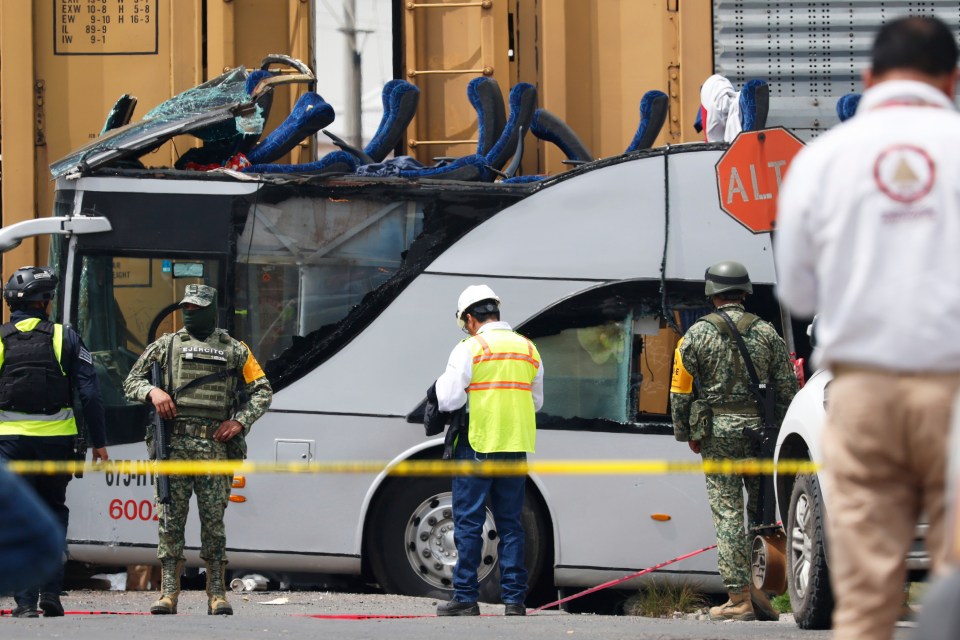 Soldiers and rescue personnel at the scene of a train and bus accident.
