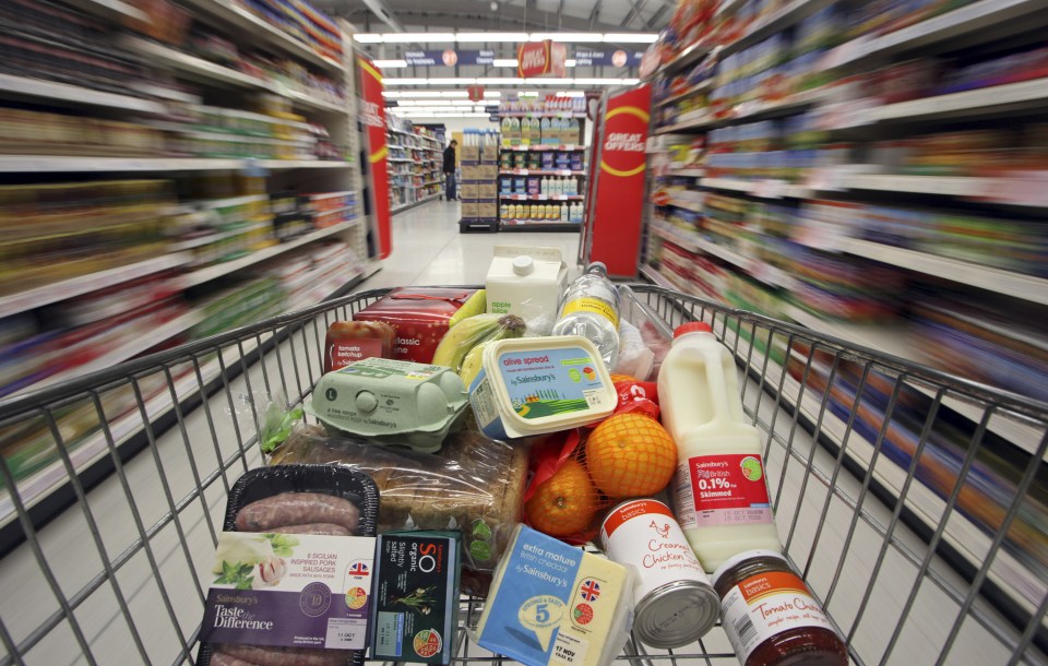 Shopping cart full of groceries in a supermarket.