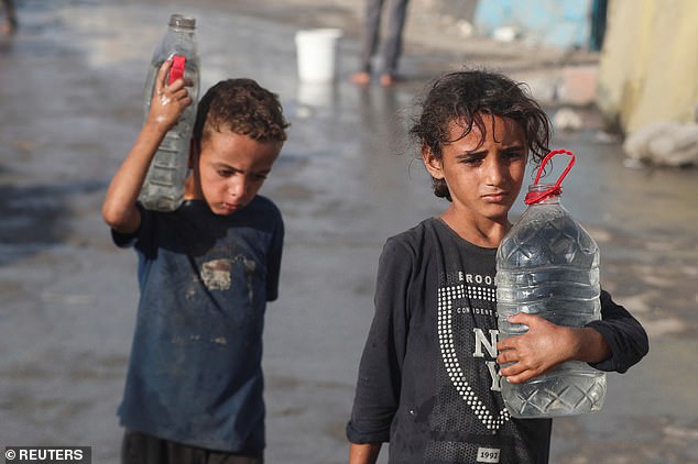 Palestinian children walk with water amid shortages in Gaza City, September 3, 2025
