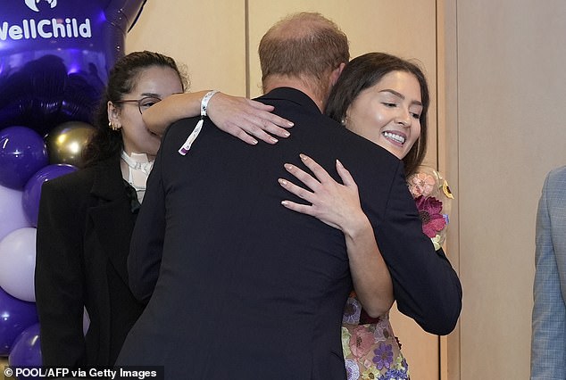 The Duke of Sussex hugs previous WellChild award recipient Evie Toombes