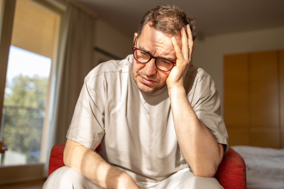 Depressed mature man sitting in a chair.