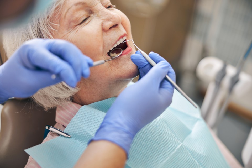 Close-up of a dentist examining a patient's teeth.
