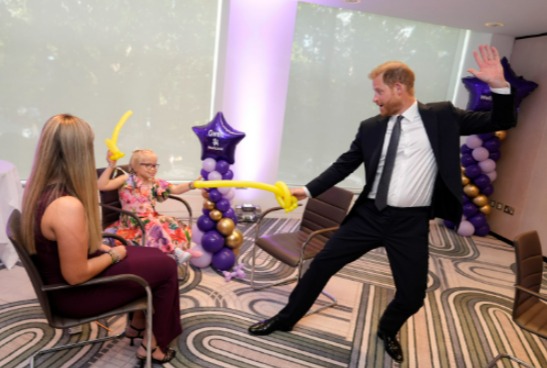 Prince Harry playfully interacting with children at a WellChild event.