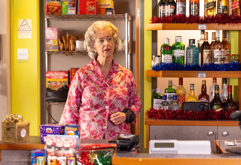 Evelyn Plummer in a shop, looking concerned.