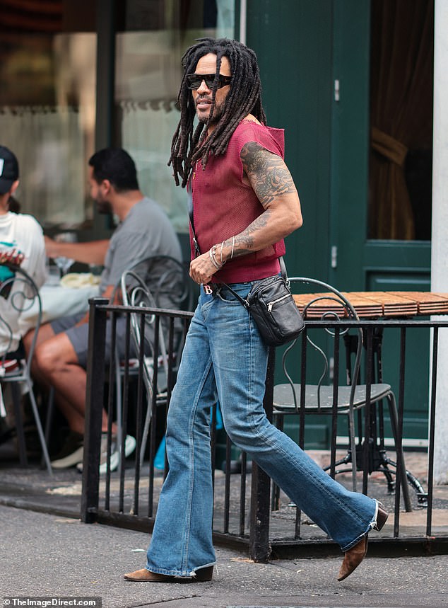 Showcasing his trademark rock god image, Lenny, 61, flaunted his age-defying physique under a sheer vest paired with flared jeans and a man bag