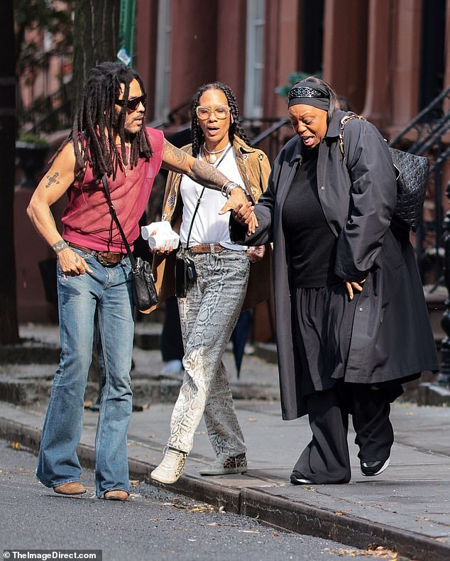 Ever the gent, Lenny held hands with another member of their party as she stepped off the pavement