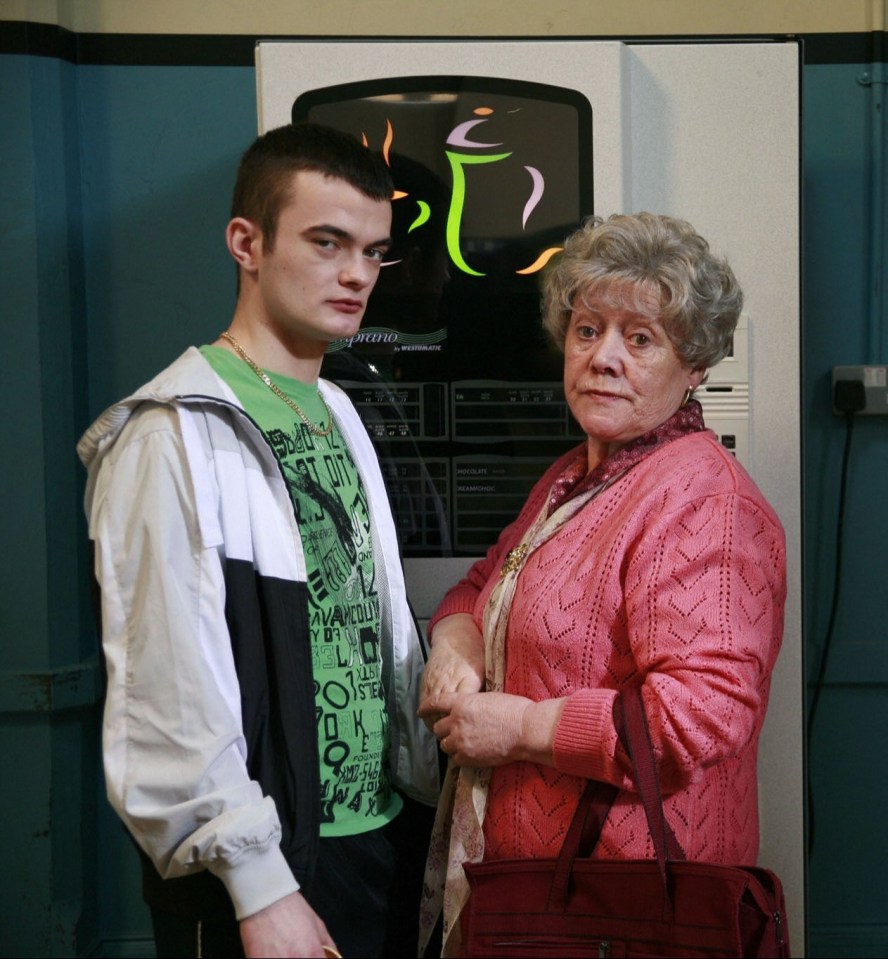 a boy in a green shirt stands next to an older woman