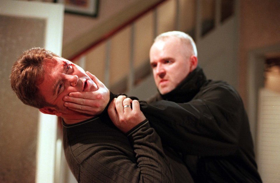 a man with a ring on his finger is holding another man 's face