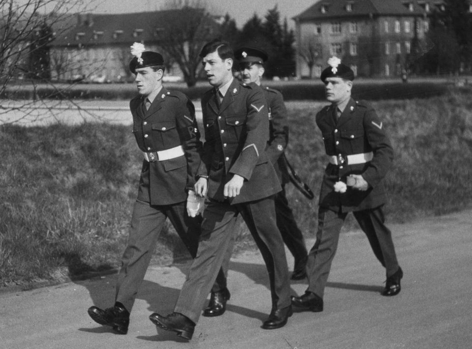 a group of men in military uniforms walk down a street