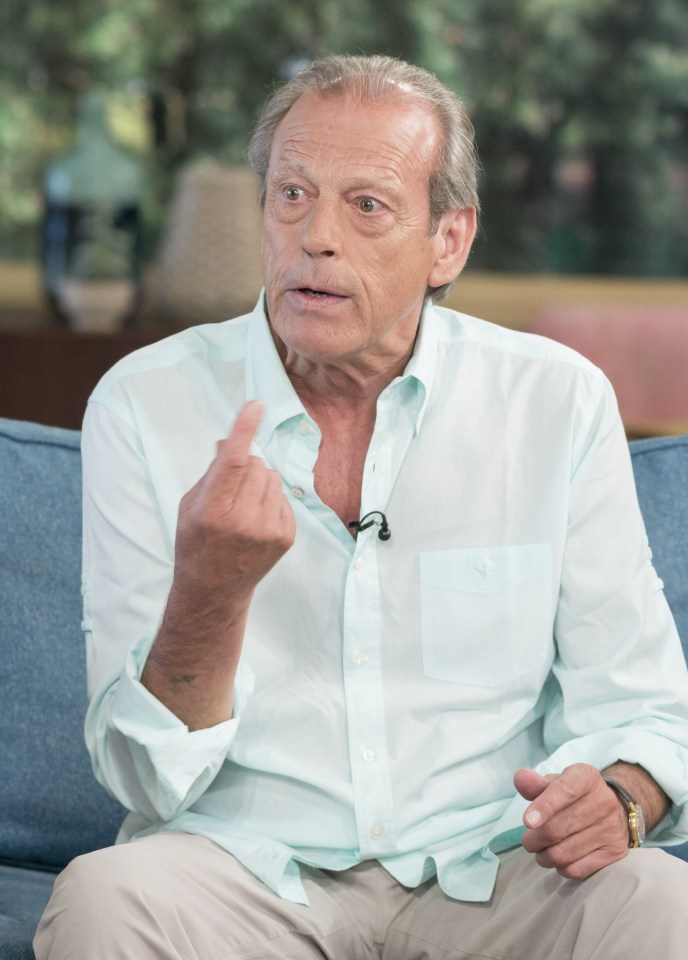 a man in a light blue shirt is sitting on a blue couch