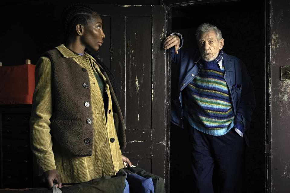 Still from a film, showing a woman and man in conversation.