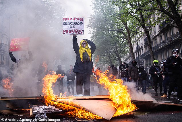 Demonstrators hold banners and flags as they protest on International Workers' day against the government's pension reform in Paris, France on May 1, 2023