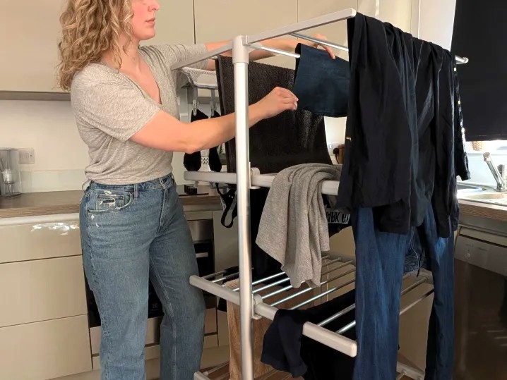 Woman using a heated clothes airer.