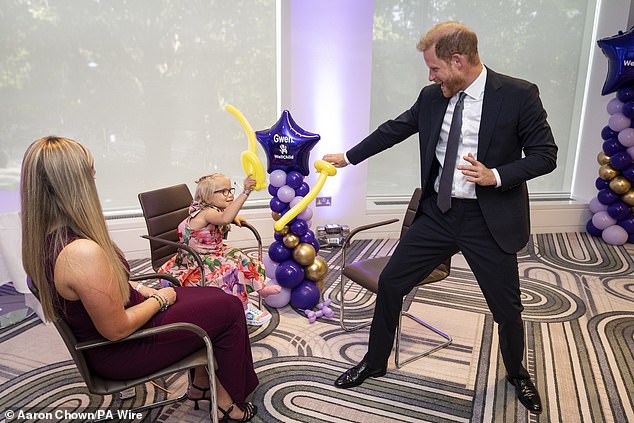 The Duke of Sussex play fights using swords made from modelling balloons with nine-year-old Gwen Foster, recipient of Inspirational Child 7-11 award, at the annual WellChild Awards 2025