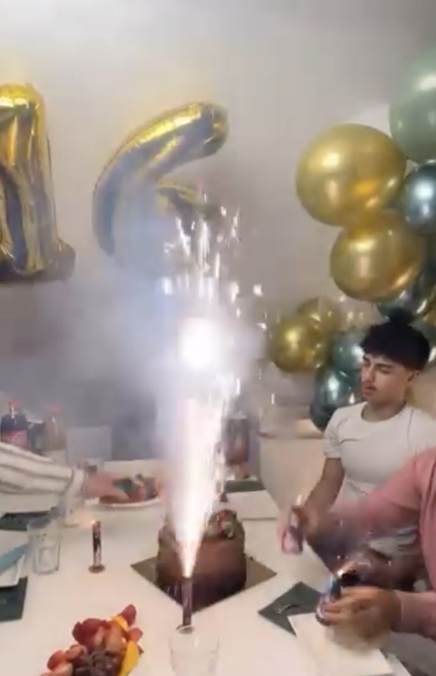 Video still of a birthday cake with fireworks instead of candles.