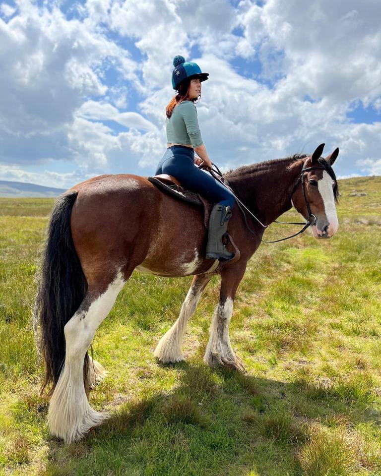Woman horseback riding in a field.