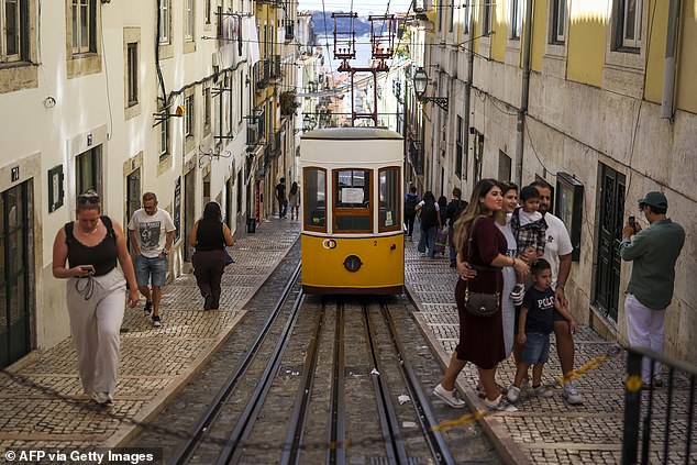 The bright yellow tram (pictured) travels along a steep hill connecting downtown Lisbon to the ancient Bairro Alto district