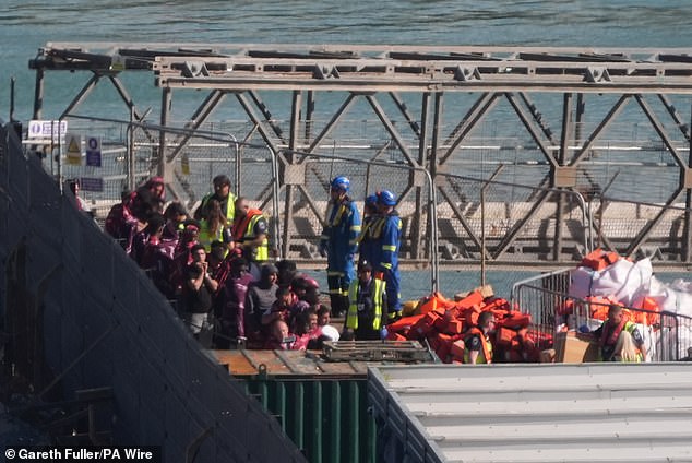 People, including some children, were seen leaving the ship wearing orange life vests and being met by officials