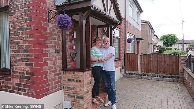 Mr Keeling and his wife Leanne Smith outside their home in Warrington - before the scaffolding was erected
