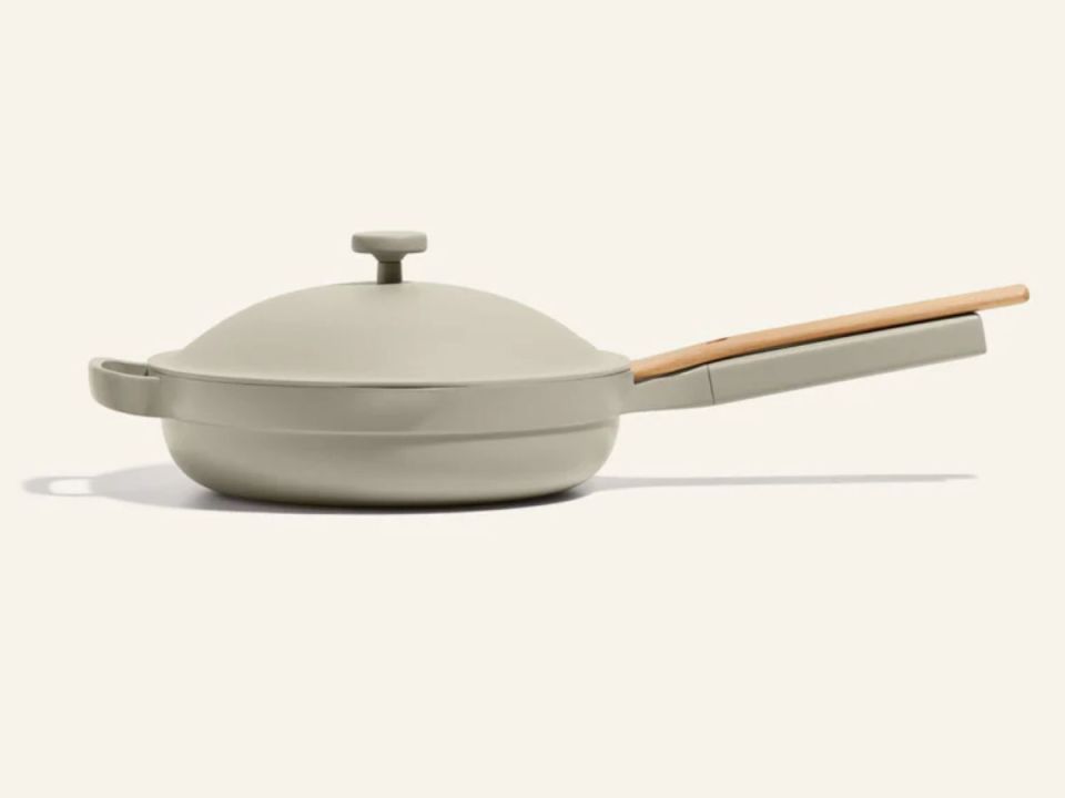 Light gray pan with lid and wooden spatula.