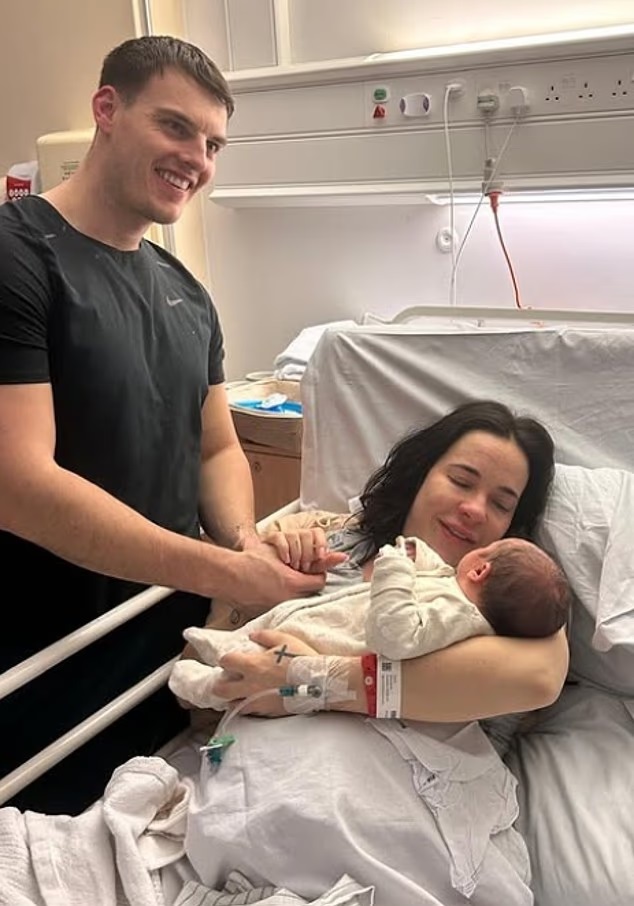 New parents holding their newborn baby in a hospital room.