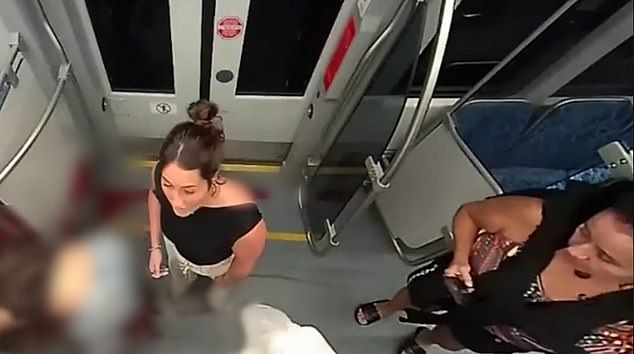 Another passenger, a woman, dressed in a colorful top, cropped black pants with a sweater around her neck, was also seen whipping out her phone while several people helped Zarutska