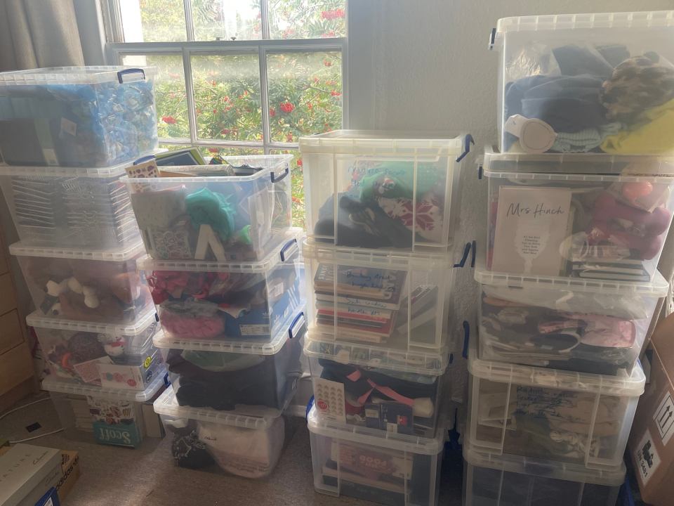 Stacks of clear plastic storage bins filled with household items.