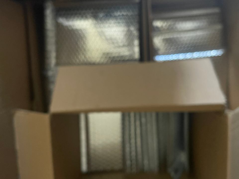 Blurry photo of cardboard boxes and bubble wrap.