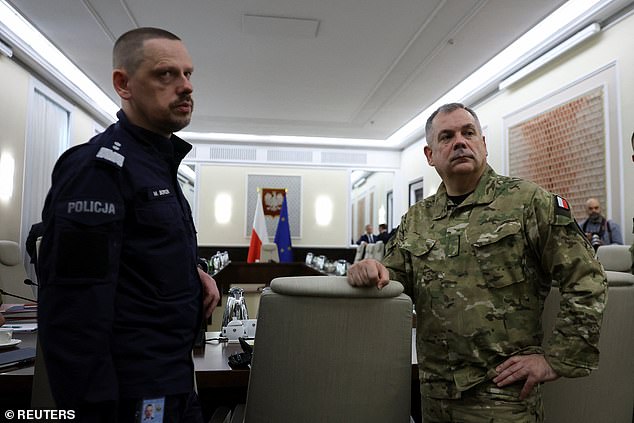 General Wieslaw Kukula, chief of the General Staff of the Polish Armed Forces and Commander-in-Chief of Police Marek Boron stand at the Chancellery of the Prime Minister for an extraordinary government meeting