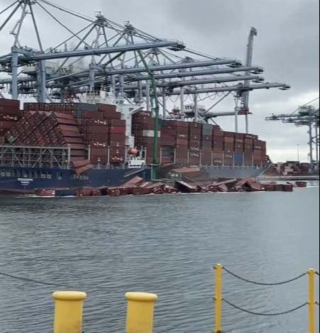 Shipping containers falling off a cargo ship into the water.