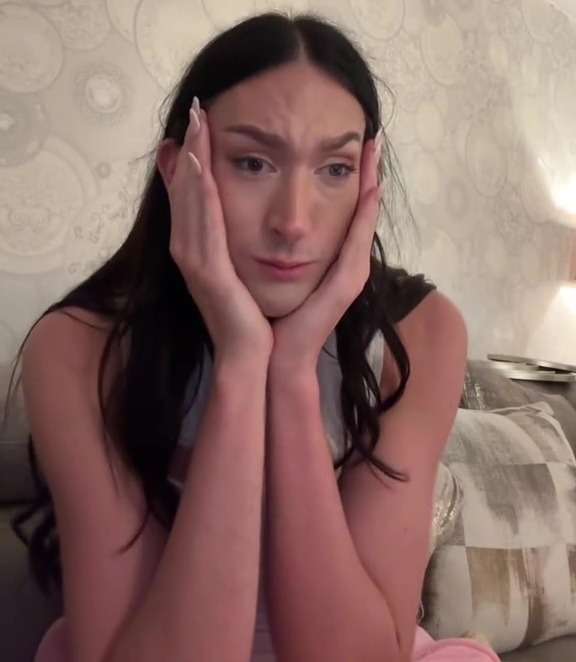 Upset young woman addressing viewers on camera.