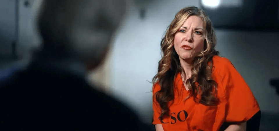 Woman in orange jumpsuit being interviewed.