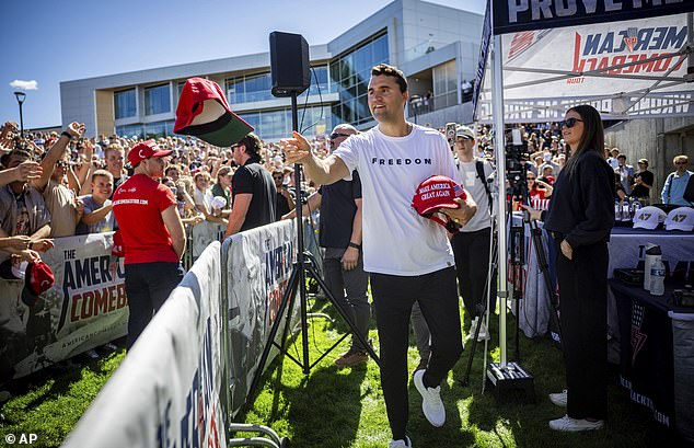 Charlie Kirk hands out hats before speaking at Utah Valley University in Orem, Utah, Wednesday, Sept. 10, 2025. (Tess Crowley/The Deseret News via AP)