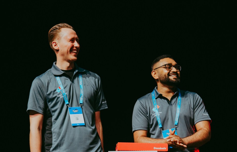 Two smiling Domino's employees at an event.