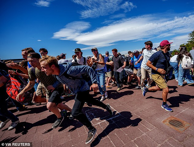 Hours afterward, a second 'person of interest' was detained, however, FBI Director Kash Patel confirmed to X that this individual was also released after interrogation - meaning the manhunt for the shooter continues (pictured: attendees fleeing from scene)