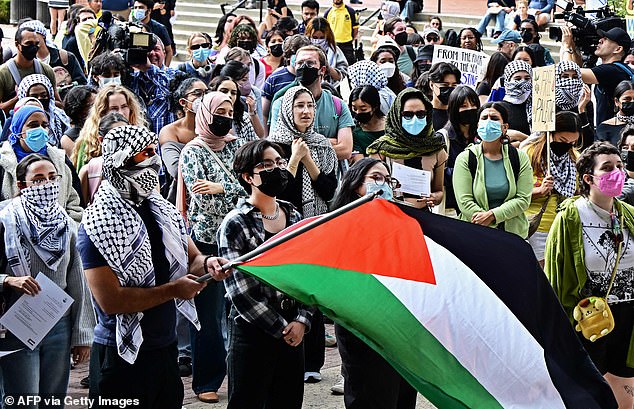 A person held a Palestinian flag as students participated in a 'Walkout to fight Genocide and Free Palestine' at UCLA on October 25, 2023