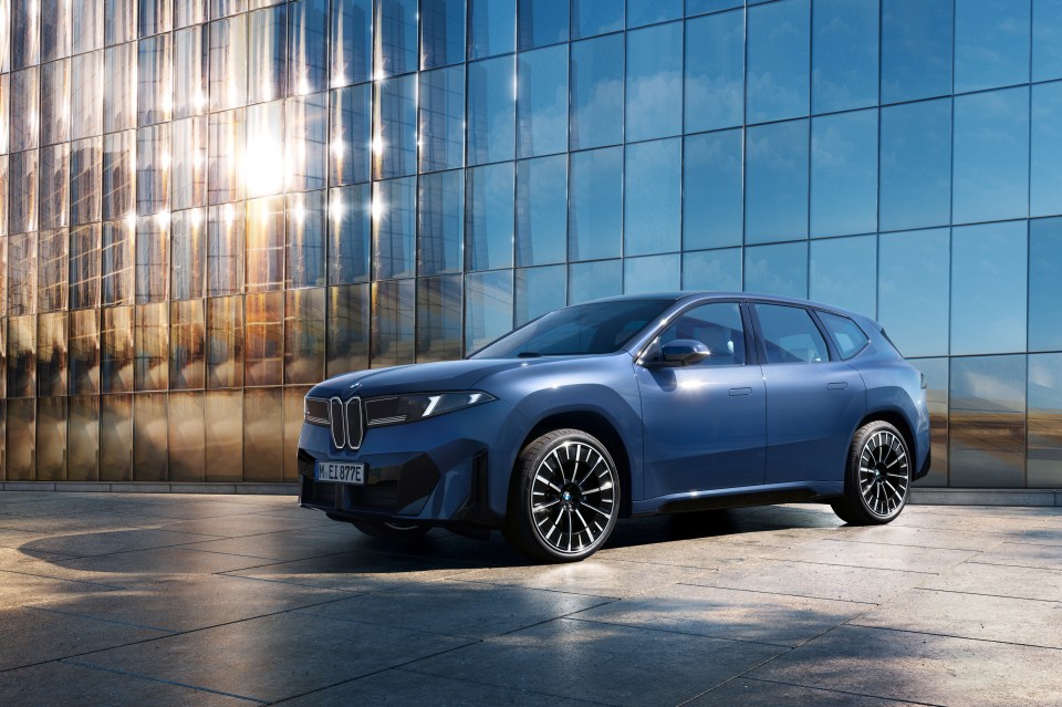 BMW iX1 parked in front of a modern building.