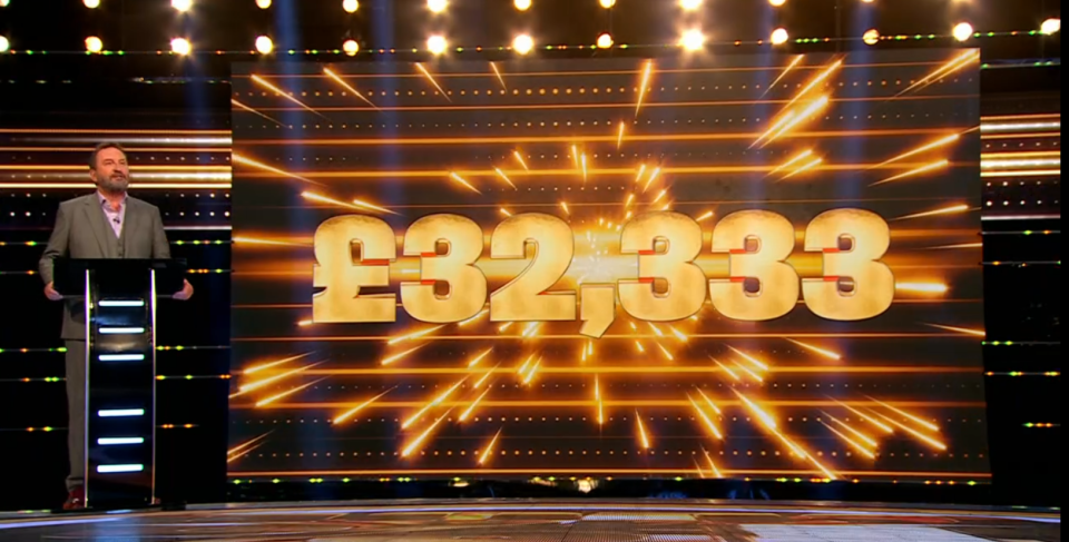 A man announcing a prize of £32,333.