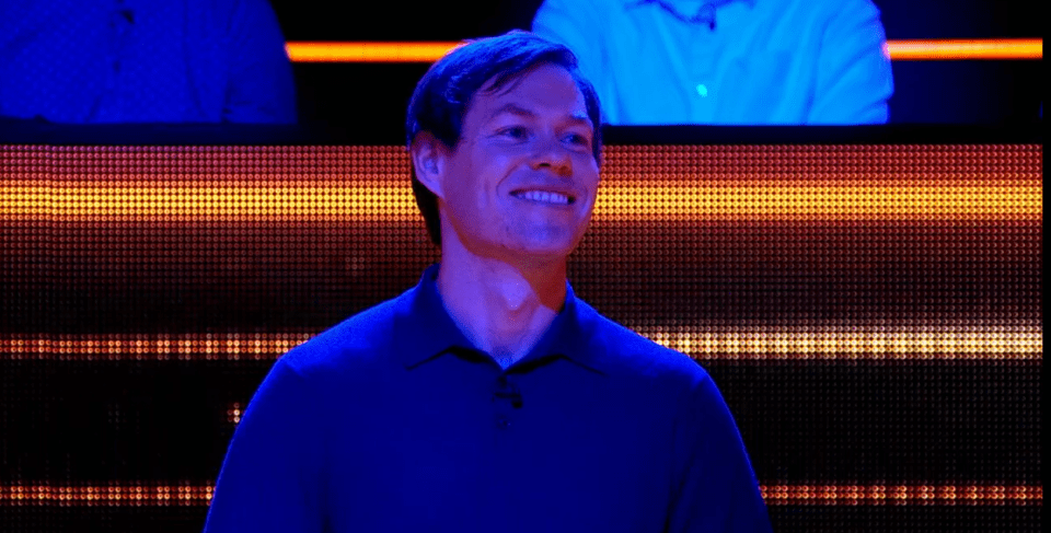 Man smiling in blue shirt.