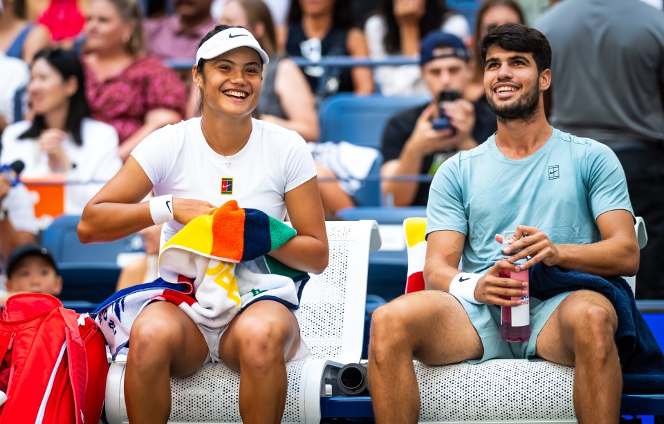 Emma Raducanu and Carlos Alcaraz sitting together during a tennis match.