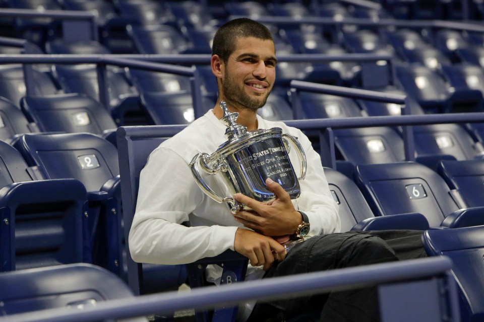 Carlos Alcaraz holding the US Open men's singles championship trophy.