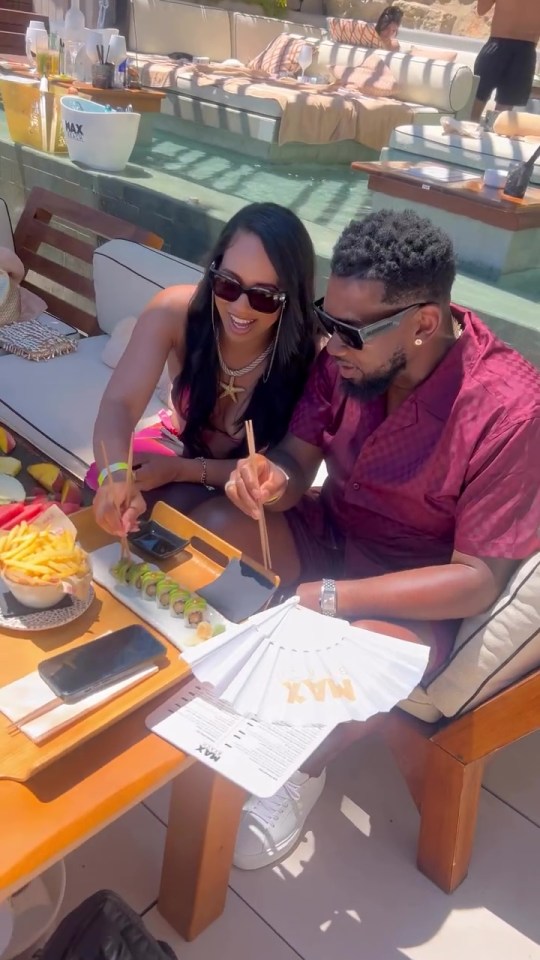 A man and woman eating sushi by a pool.