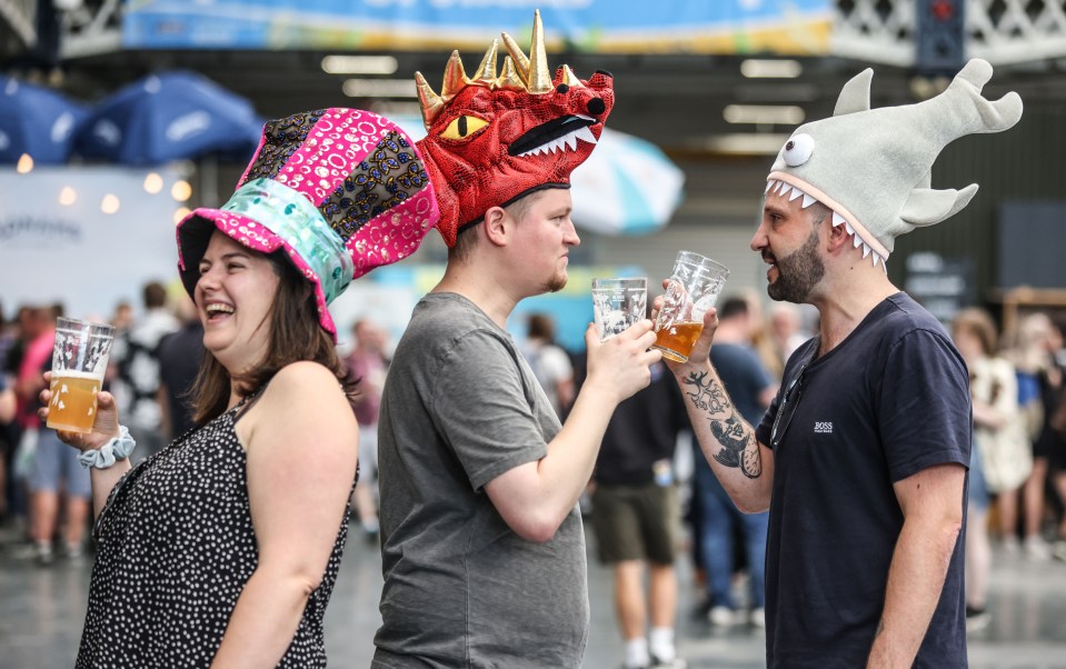 People in costume enjoying beer at a festival.