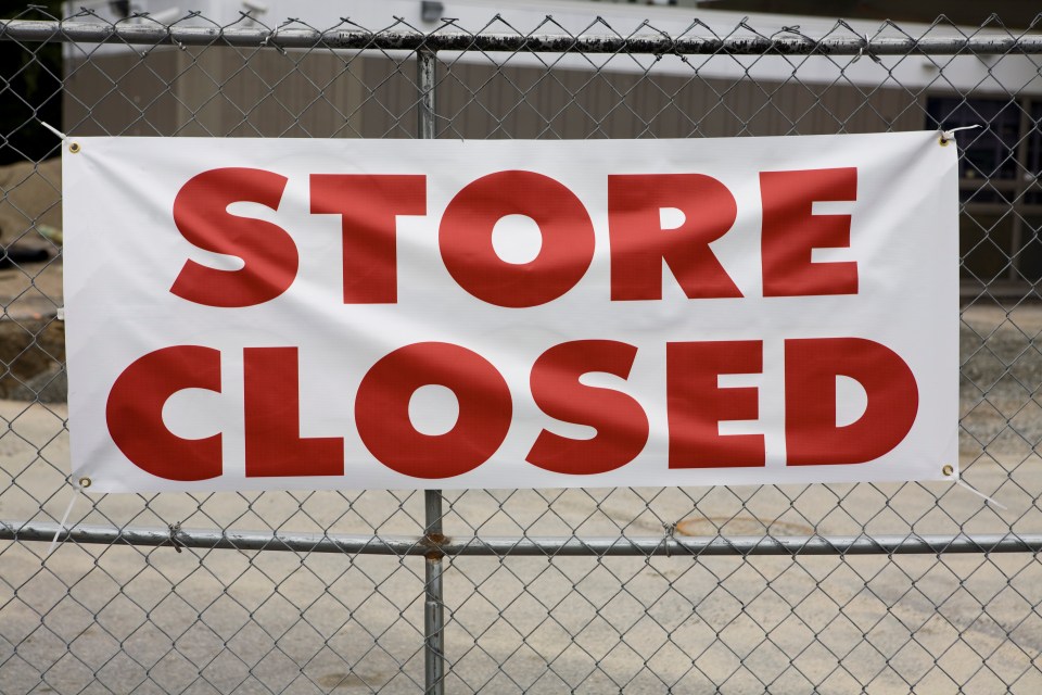 a person is holding a red sign that says closed