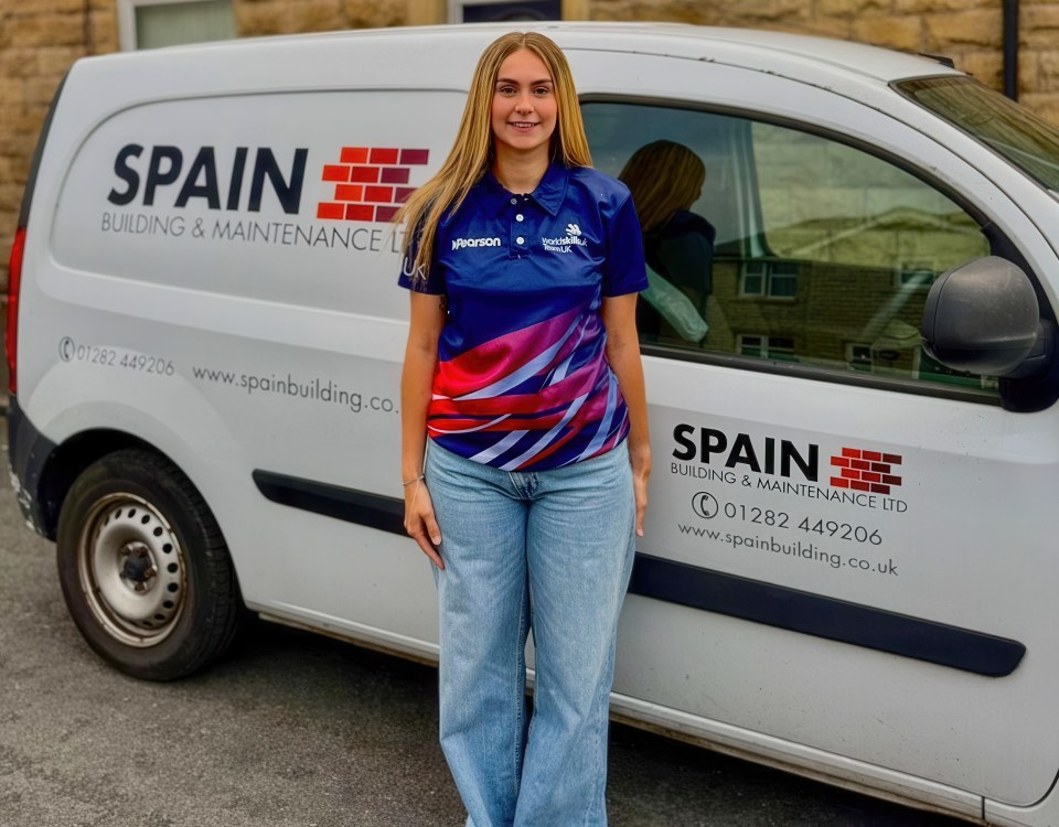 Woman standing by Spain Building & Maintenance van.